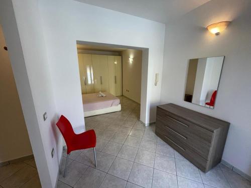 a bathroom with a red chair and a dresser at Casa Camere Pistis in Assemini