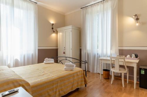 a bedroom with a bed and a desk and a table at Villa Romantica Wellness & SPA in Lucca