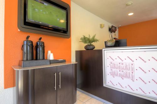 a flat screen tv on a wall next to a counter at Motel 6-Rancho Mirage, CA - Palm Springs in Rancho Mirage