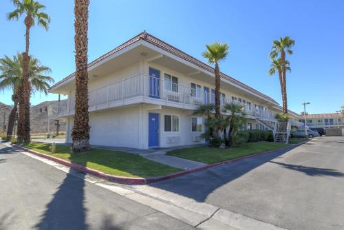 a house with palm trees in front of a street at Motel 6-Rancho Mirage, CA - Palm Springs in Rancho Mirage