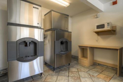 a kitchen with a stainless steel refrigerator and a microwave at Motel 6-Rancho Mirage, CA - Palm Springs in Rancho Mirage