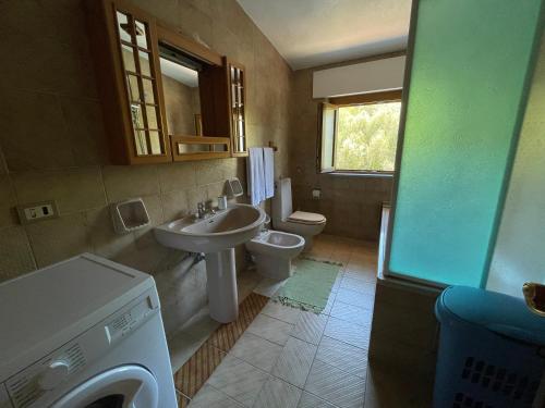 y baño con lavabo, aseo y lavadora. en Casa Panorama, en Posada
