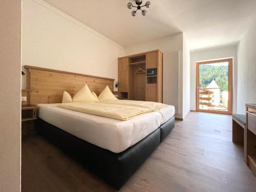 a bedroom with a large white bed in a room at Hotel & Suites Glück Auf in Mayrhofen