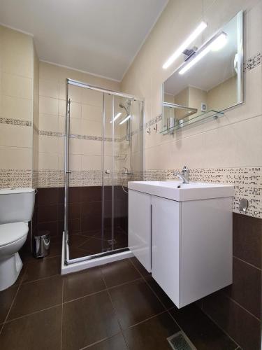 a bathroom with a shower and a sink and a toilet at Aparthotel Happy in Primorsko