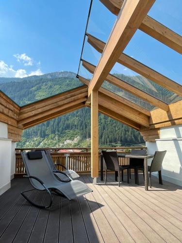 a patio with a table and chairs on a deck at Hotel & Suites Glück Auf in Mayrhofen