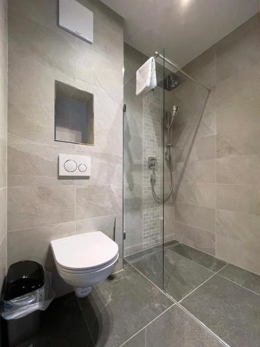 a bathroom with a toilet and a glass shower at Hotel & Suites Glück Auf in Mayrhofen
