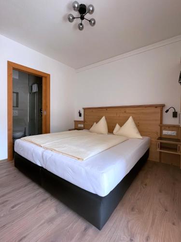 a bedroom with a large bed with white sheets at Hotel & Suites Glück Auf in Mayrhofen