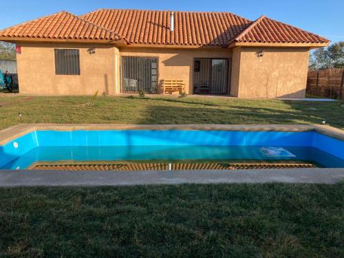 uma piscina em frente a uma casa em Casa de campo Mostazal / Hogar para descansar em El Rincón