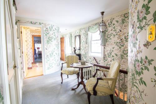 uma sala de jantar com papel de parede floral e uma mesa e cadeiras em Aiken Manor B&B em Franklin