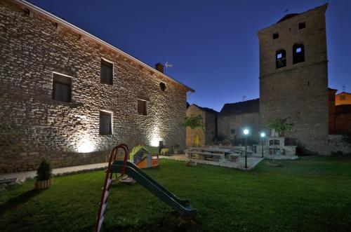 a playground in a yard next to a brick building at Casa Rural Perico in Fiscal