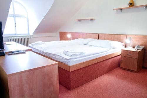 A bed or beds in a room at Lázně Jupiter Bechyně