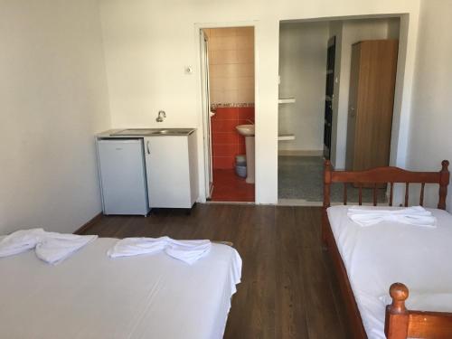a room with two beds and a kitchen with a sink at Vila Syhana in Ulcinj