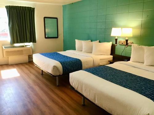 a hotel room with two beds and a window at Travelodge Inn & Suites by Wyndham Missoula University Park in Missoula