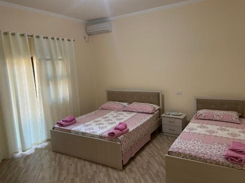 twee bedden in een slaapkamer met roze kussens erop bij Vila Leo in Golem