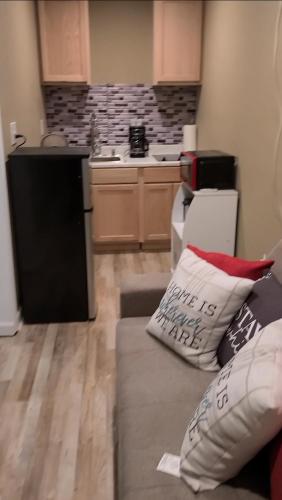 a living room with a couch and a kitchen at JAMMS tiny home in Baton Rouge