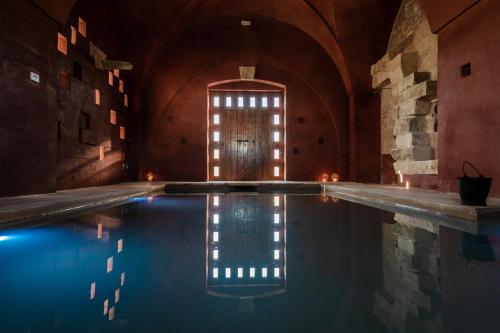 an indoor swimming pool in a building with a window at Masseria Palombara Relais & SPA - Adults only in Manduria