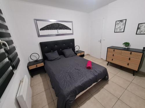 a bedroom with a large bed with a black bedspread at Villa avec piscine sans vis-à-vis in Caux-et-Sauzens