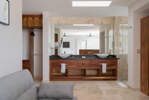 a bathroom with two sinks and a large mirror at Valhalla Residences by Biwa in Tulum