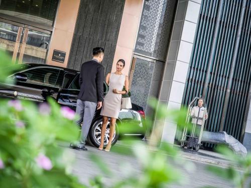 a man and a woman standing outside of a building at InterContinental Hanoi Landmark72 by IHG in Hanoi