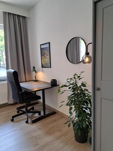 an office with a desk and a chair and a mirror at Waldstadt-Apartments in Iserlohn
