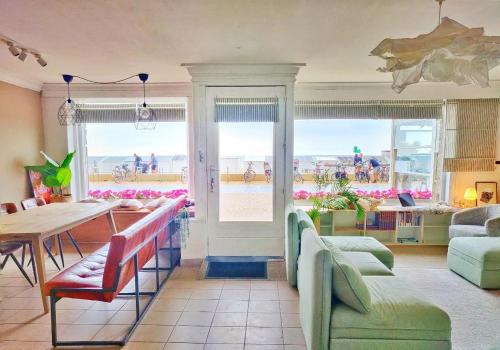 - un salon avec une table et une vue sur la plage dans l'établissement Seaview Eclectic Suite, à Ostende