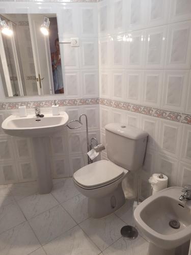 a white bathroom with a toilet and a sink at CasaBel - Playa in Torrox Costa