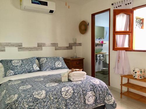 a bedroom with a bed with a blue and white blanket at Luna Nueva Casa de Huéspedes in Ríohacha