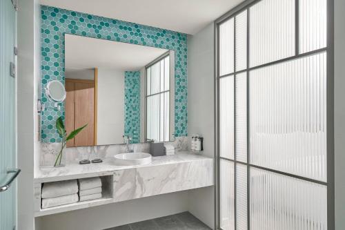 a bathroom with a sink and a mirror at Holiday Inn Resort Ho Tram Beach by IHG in Ho Tram