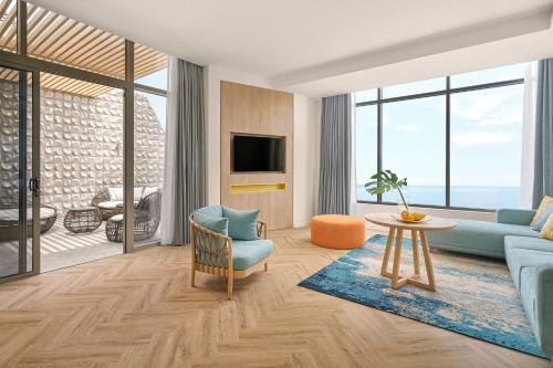 a living room with a blue couch and a table at Holiday Inn Resort Ho Tram Beach by IHG in Ho Tram