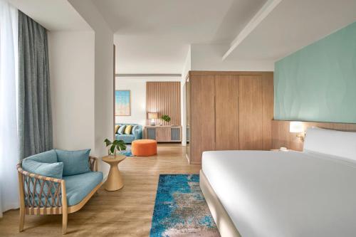 a hotel room with a bed and a chair at Holiday Inn Resort Ho Tram Beach by IHG in Ho Tram