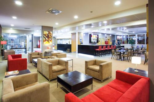 a lobby with couches and chairs and a bar at Holiday Inn Express Lisbon-Oeiras by IHG in Oeiras