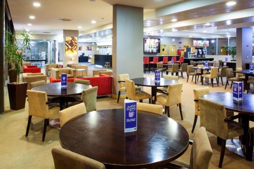 a restaurant with tables and chairs in a cafeteria at Holiday Inn Express Lisbon-Oeiras by IHG in Oeiras