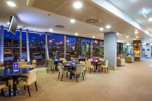 a restaurant with tables and chairs and a view of the city at Holiday Inn Express Lisbon-Oeiras by IHG in Oeiras