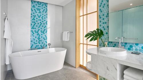 a bathroom with a large tub and a sink at Holiday Inn Resort Ho Tram Beach by IHG in Ho Tram