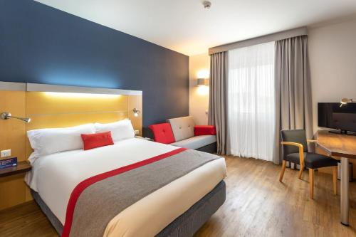 a hotel room with a large bed and a desk at Holiday Inn Express Lisbon-Oeiras by IHG in Oeiras