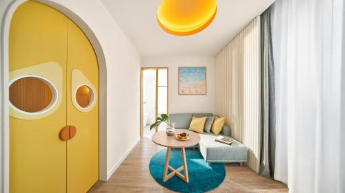 a living room with a yellow door and a table at Holiday Inn Resort Ho Tram Beach by IHG in Ho Tram