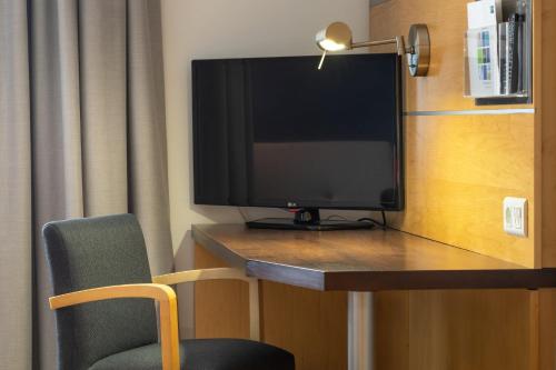 a television on a desk in a hotel room at Holiday Inn Express Lisbon-Oeiras by IHG in Oeiras
