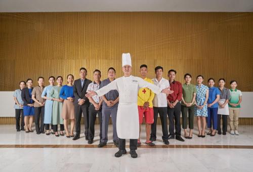 a man in a chefs outfit standing in front of a group of people at Holiday Inn Resort Ho Tram Beach by IHG in Ho Tram