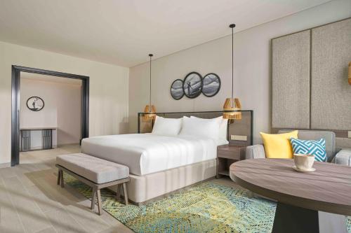 a bedroom with a large bed and a table at Crowne Plaza Phu Quoc Starbay by IHG in Phu Quoc