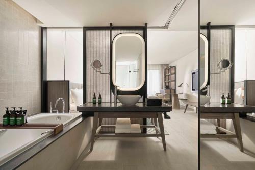 a bathroom with a sink and a tub and a mirror at Crowne Plaza Phu Quoc Starbay by IHG in Phu Quoc