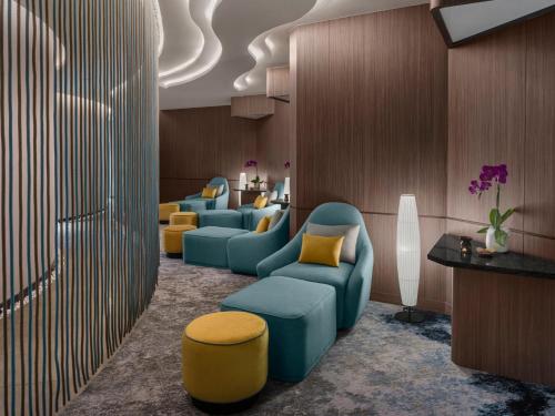 a waiting room with blue chairs and yellow chairs at Crowne Plaza Phu Quoc Starbay by IHG in Phu Quoc