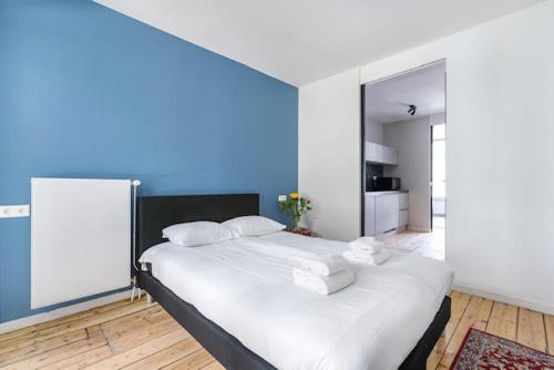 a large bed in a room with a blue wall at Resident Moose in Amsterdam