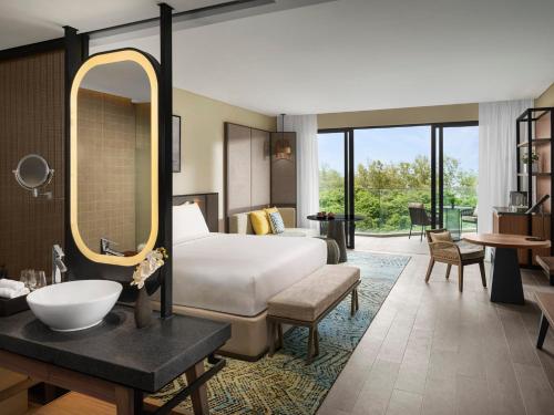 a hotel room with a bed and a mirror at Crowne Plaza Phu Quoc Starbay by IHG in Phu Quoc