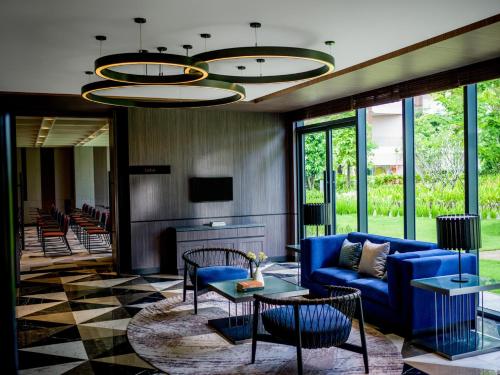 a lobby with a blue couch and chairs and a fireplace at Crowne Plaza Phu Quoc Starbay by IHG in Phu Quoc