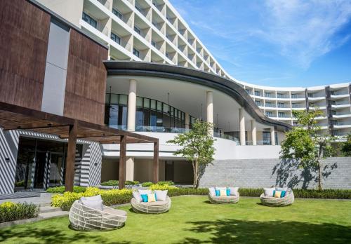 an exterior view of a building with chairs in a yard at Crowne Plaza Phu Quoc Starbay by IHG in Phu Quoc