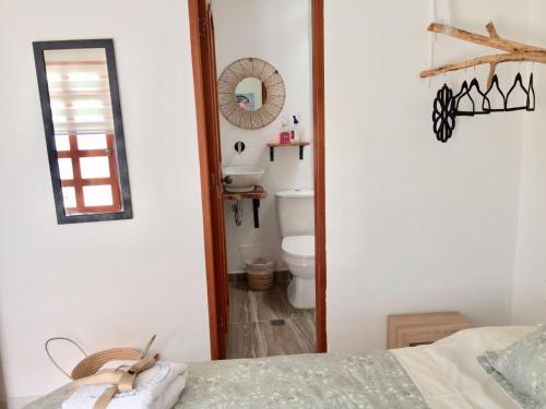 a bathroom with a toilet and a mirror at Luna Nueva Casa de Huéspedes in Ríohacha