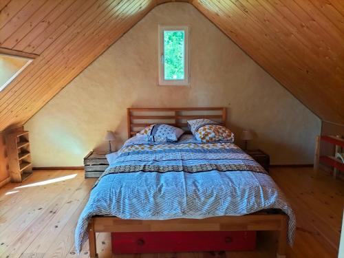 une chambre avec un lit dans un grenier dans l'établissement Maison bord de Loire, à Rochefort-sur-Loire