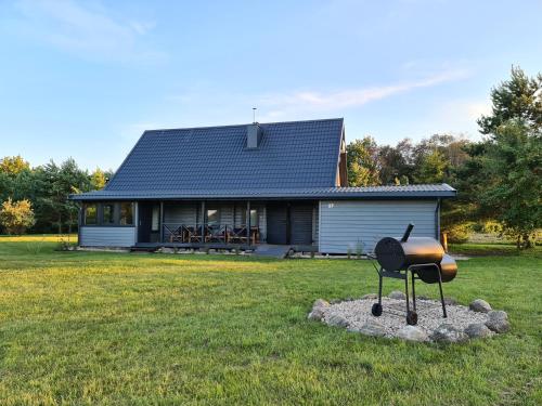 una barbacoa frente a una casa en Rubikių Meldynas Anykščiai, en Anykščiai