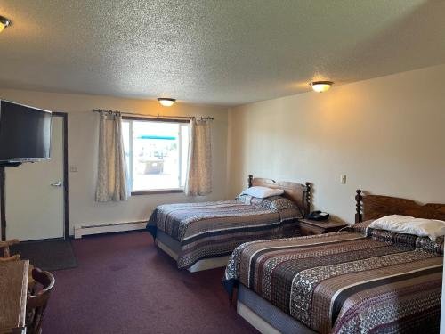 a hotel room with two beds and a television at Barnesville Motel 