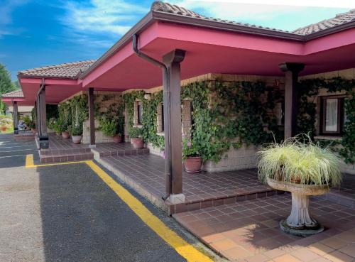 a pink building with plants on the side of it at Hotel Rural "La Ruta De Cabrales" in Mestas de Con